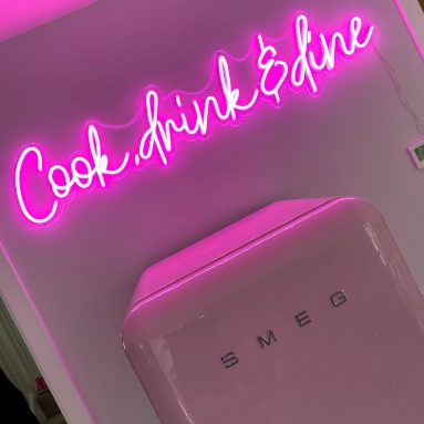 Pink Custom Neon® Cook Drink & Wine sign above a Smeg fridge