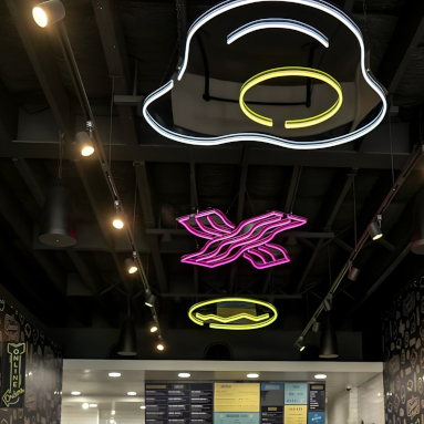 Custom Neon® eggs and bacon brand art suspended from the ceiling @crackedeggery