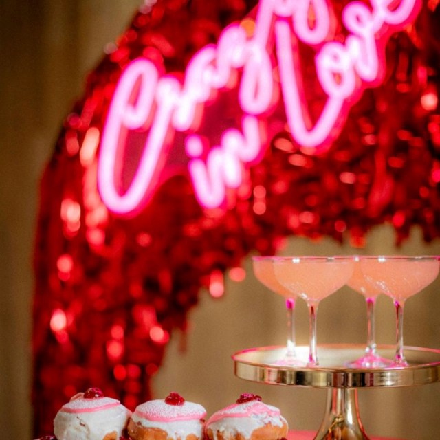 Pink Crazy in Love Custom Neon® sign on a deep red streamer backdrop @thewarehouse @styleourparty @nicstephensphotography