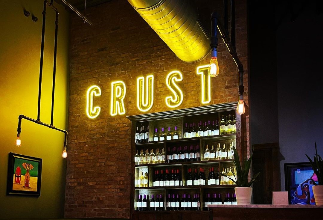 Orange Custom Neon® restaurant sign on brick wall @crust_pizza