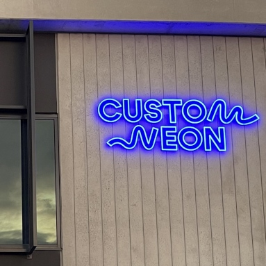 Custom Neon® blue logo mounted to the office buildint's exterior @customneon