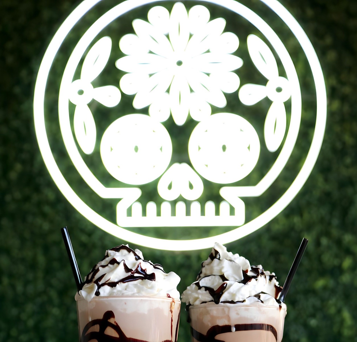 White Custom Neon® Mexican sugar skull artwork on green wall @delsurtacqueria