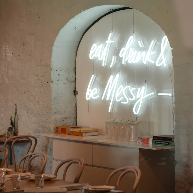 Eat Drink & Be Messy white Custom Neon® sign hanging in an alcove @justinlaneest