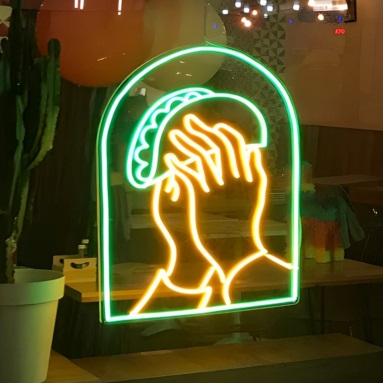 Custom Neon® LED neon art of prayer hands holding taco shells in the window at @elsantogeelong