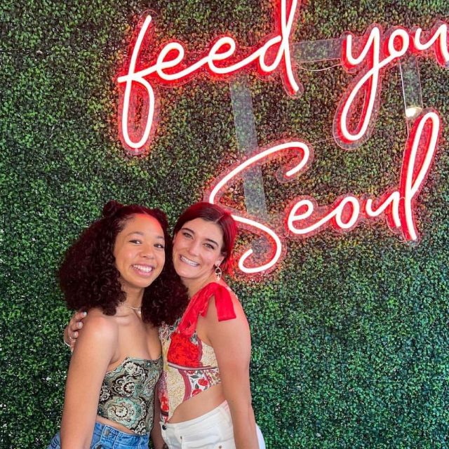 Feed Your Seoul red Custom Neon® sign on a green wall as a selfie backdrop @seoulspice