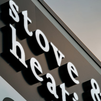 Close up of a front lit sign for a stove and heating showroom