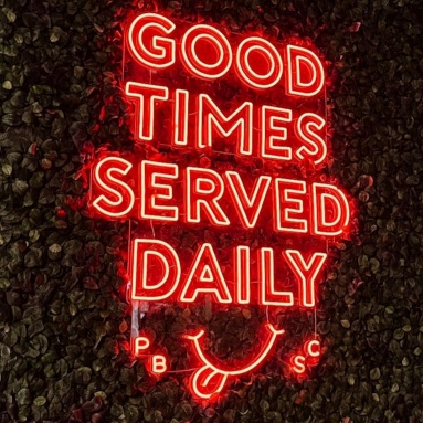Large red Custom Neon® sign on a grasswall @ponyboat.socialclub