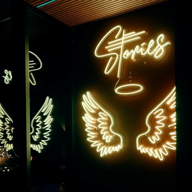 Custom Neon® angel wings and halo on an instagram wall in a nightclub @stories.au