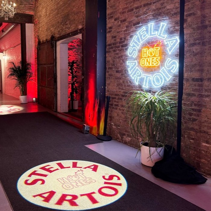 Hot Ones Stella Artois Custom Neon® logo signs on a rustic brick wall at the Hot Ones Live event in Chicago IL organised by @thesuperproducers @emdahlquist