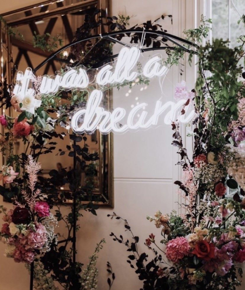 Custom Neon® white wedding sign hung on a metal arch as a selfie photo frame 