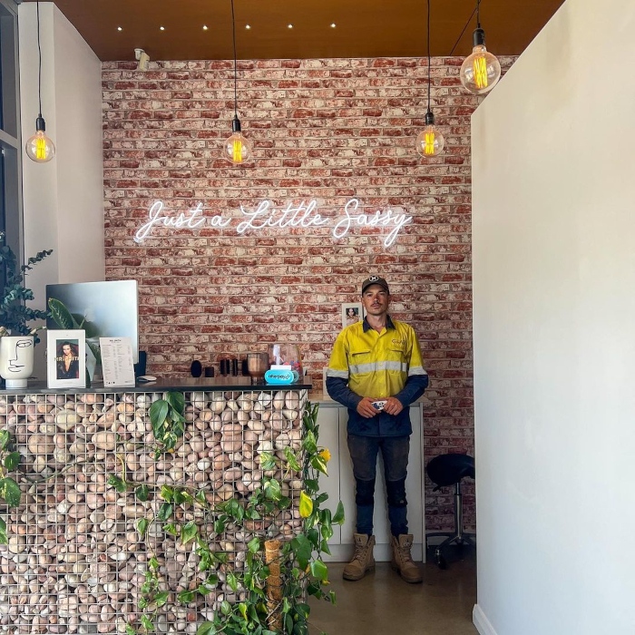 White Custom Neon® sign on a brick wall @czarelectrical