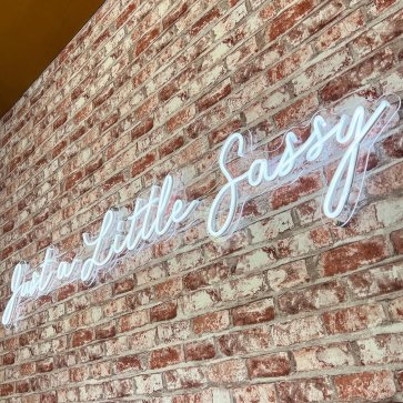 White Custom Neon® sign on a brick wall @czarelectrical