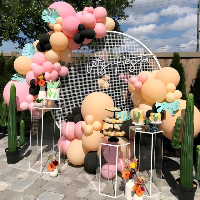 Custom Neon® Let's Fiesta sign attached to a white wire mesh frame with a balloon arch and SouthWestern party props - event decor by @decorandfiesta