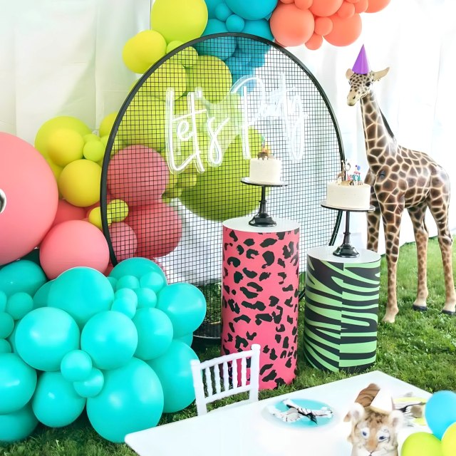 Custom Neon® white Let's Party sign on a wire mesh backing surrounded by a balloon waterfall, large giraffe, safari print cake stands and other party props - event decor by @decorandfiesta