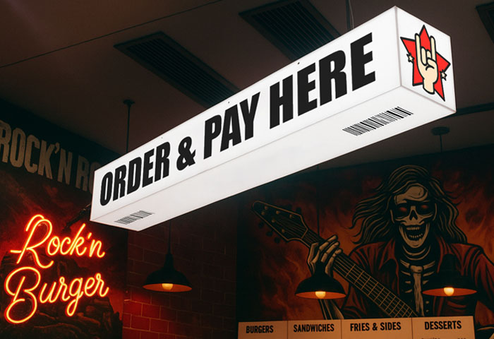 Fully illuminated sign suspended from a ceiling