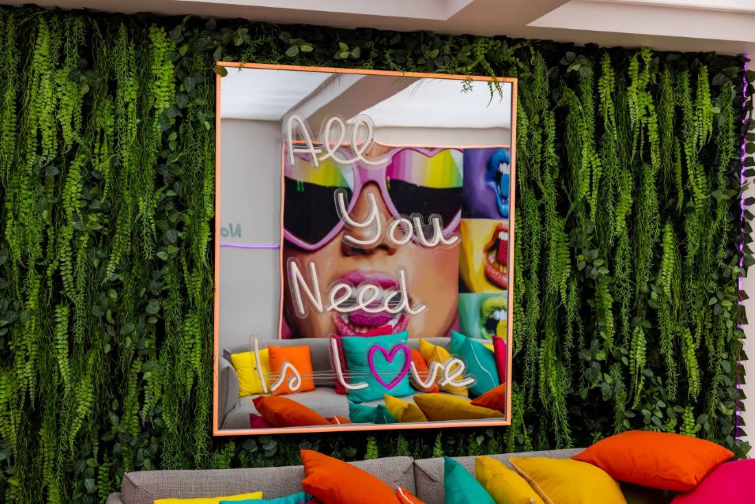 Custom Neon® All You Need is Love sign on a mirror in the Love Island Australia Villa lounge room
