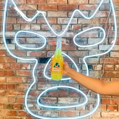 Custom Neon® wall art of a blue luchador mask installed on a brown brick wall @onetacoaustin