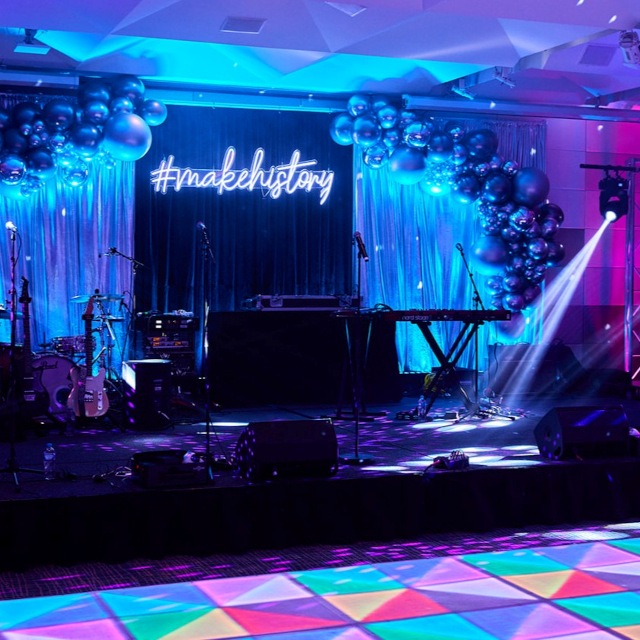 Custom Neon® white personalized stage sign behind the artist during a concert @jakescottmusic