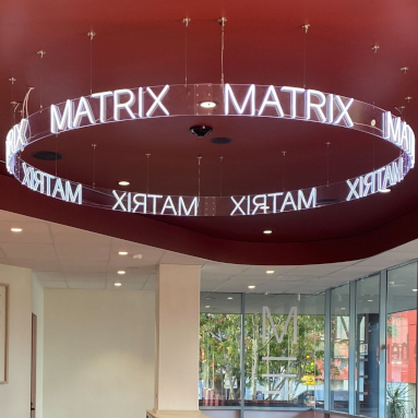 Custom Neon&reg; curved business name sign suspended from the ceiling @matrixeducation