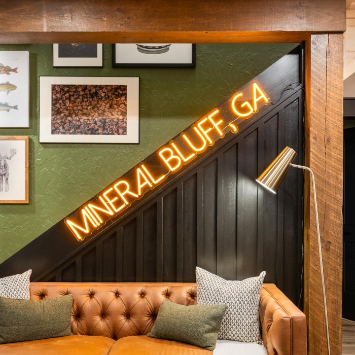 Mineral Bluff GA orange LED Custom Neon® sign on the wooden staircase in a cabin with sage green and wooden decor designed by Somerled
