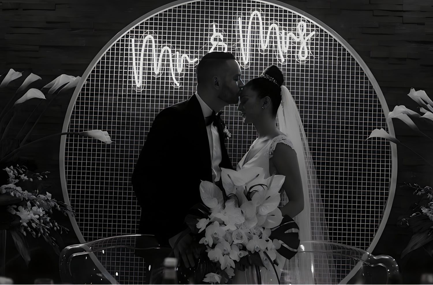 Custom Neon® white Mr & Mrs wedding sign attached to a wire mesh frame behind the newly married couple