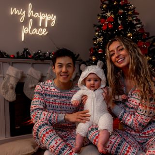 Custom Neon® white My Happy Place sign above the mantlepiece next to a Christmas tree and decorations