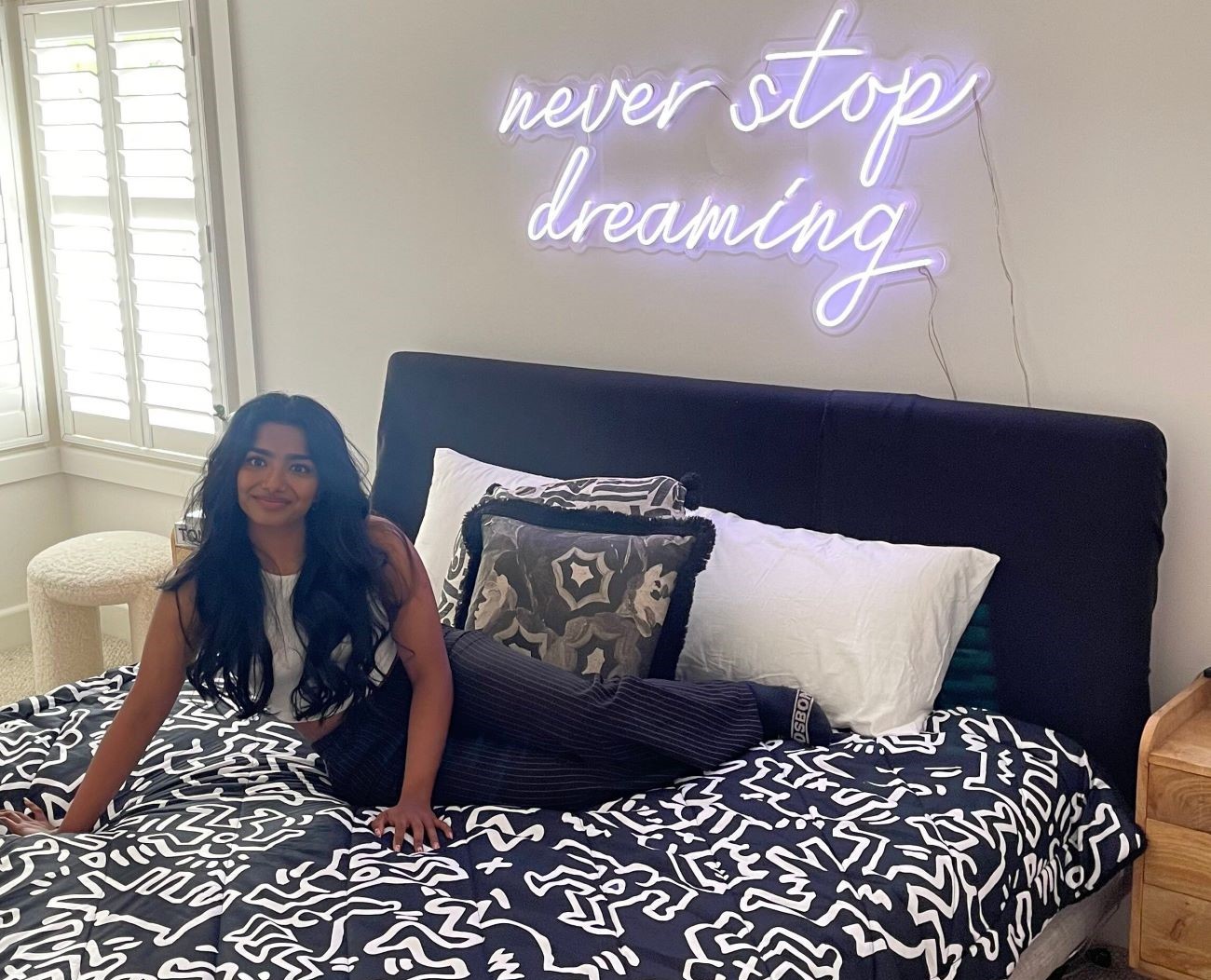 Never Stop Dreaming Custom Neon® quote sign above a bed
