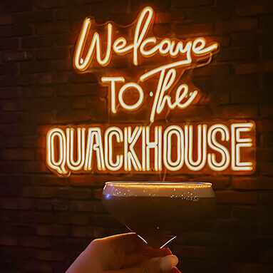 Custom Neon® warm white cocktail bar tagline sign
