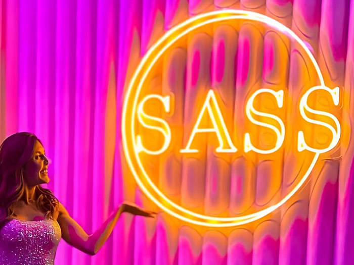 Custom Neon® large yellow illuminated gym logo on pink wall