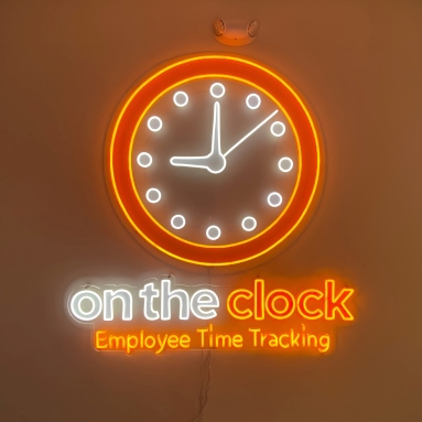 Orange Custom Neon® logo in an office @ontheclockemployeetimetracking