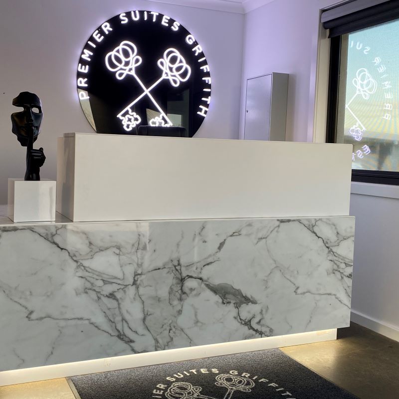 Custom Neon® white sign on black backing @premiersuitegriffith