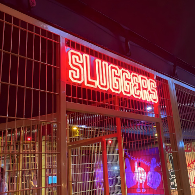 Custom Neon® red waterproof sign on a batting cage @playatsluggers