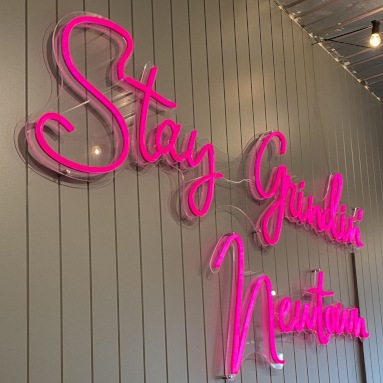 Large pink slogan sign by Custom Neon® on a dark wall @blankspace_newtown