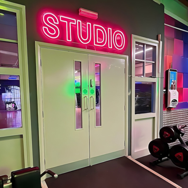 Custom Neon® pink room identification sign above the Studio door @247fitnessyork