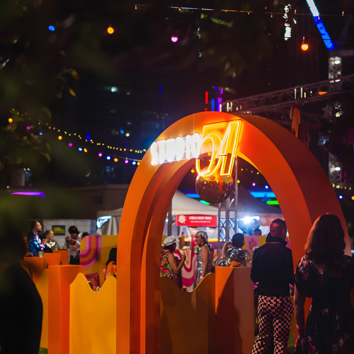 Weatherproof Custom Neon® Studio 54 sign on an arch at the entrance to an open air corporate event organized by @ultimo_catering