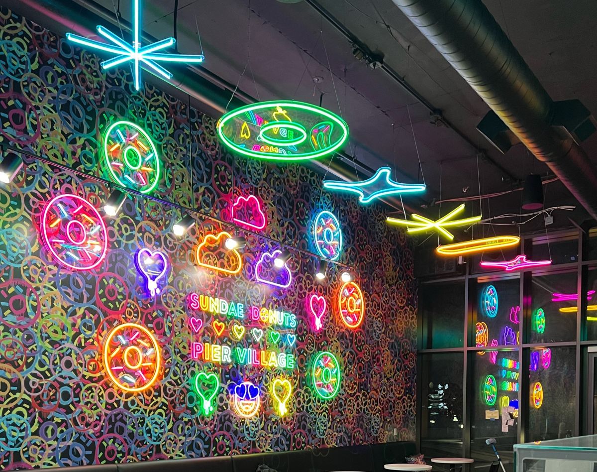 Custom Neon® wall art and suspended neon art hanging over a doughnut shop interior @sundaedonutspiervillage