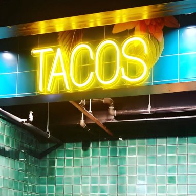 Yellow tacos sign by Custom Neon® on blue wall @florarestaurantnm