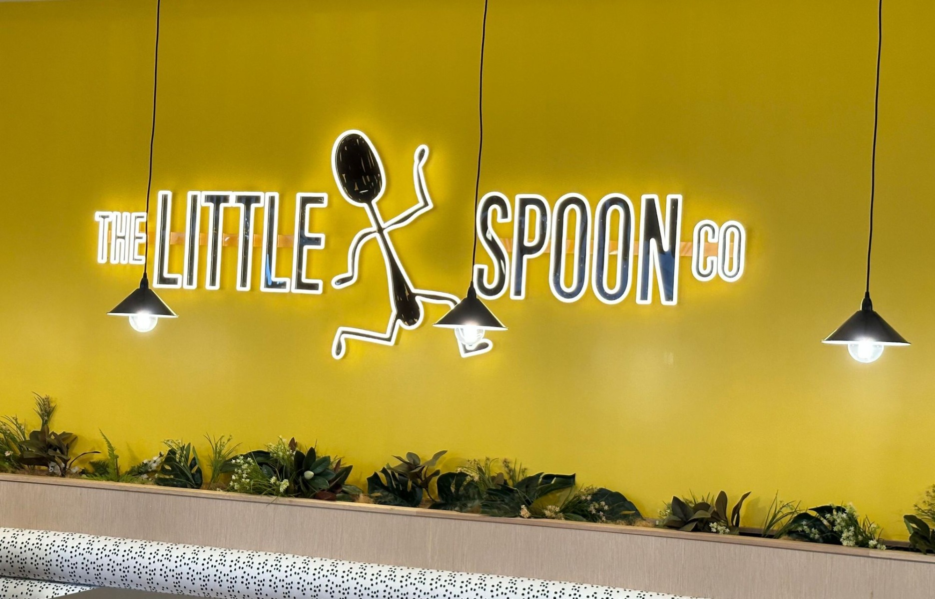 Large black and white Custom Neon® LED neon and UV printed café logcafé a yellow wall at @thelittlespoonco