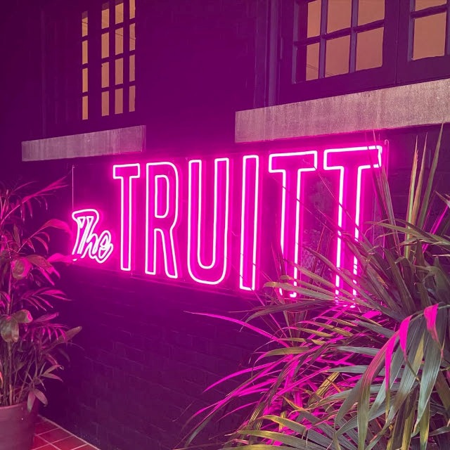 The Truitt Custom Neon® sign in the outdoor lounge area of @thetruitt