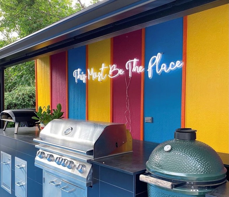 Bright white This Must Be the Place Custom Neon® sign above an outdoor BBQ kitchen @shaunaglenn