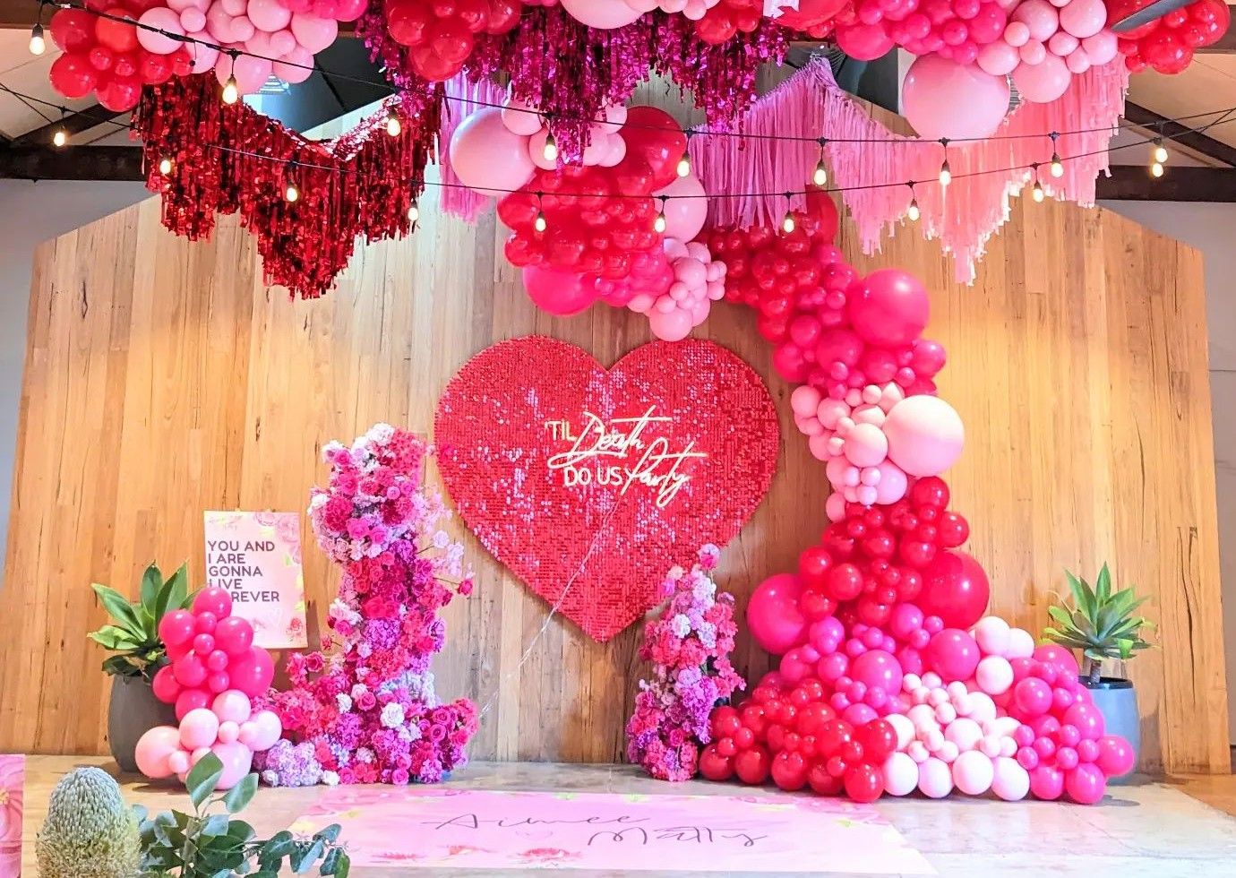 Til Death Do Us Party Custom Neon® sign on a shimmer heart as the wedding ceremony backdrop with a balloon waterfall styled @boutiqueballoons.melbourne