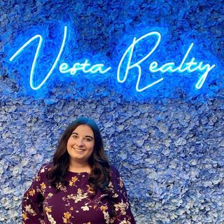 Custom Neon® blue logo on green wall @vestarealty