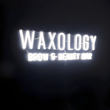 White Custom Neon® beauty salon name sign on black wall