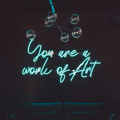 You Are a Work of Art blue Custom Neon® sign on a dark wall above plush peacock blue sofas